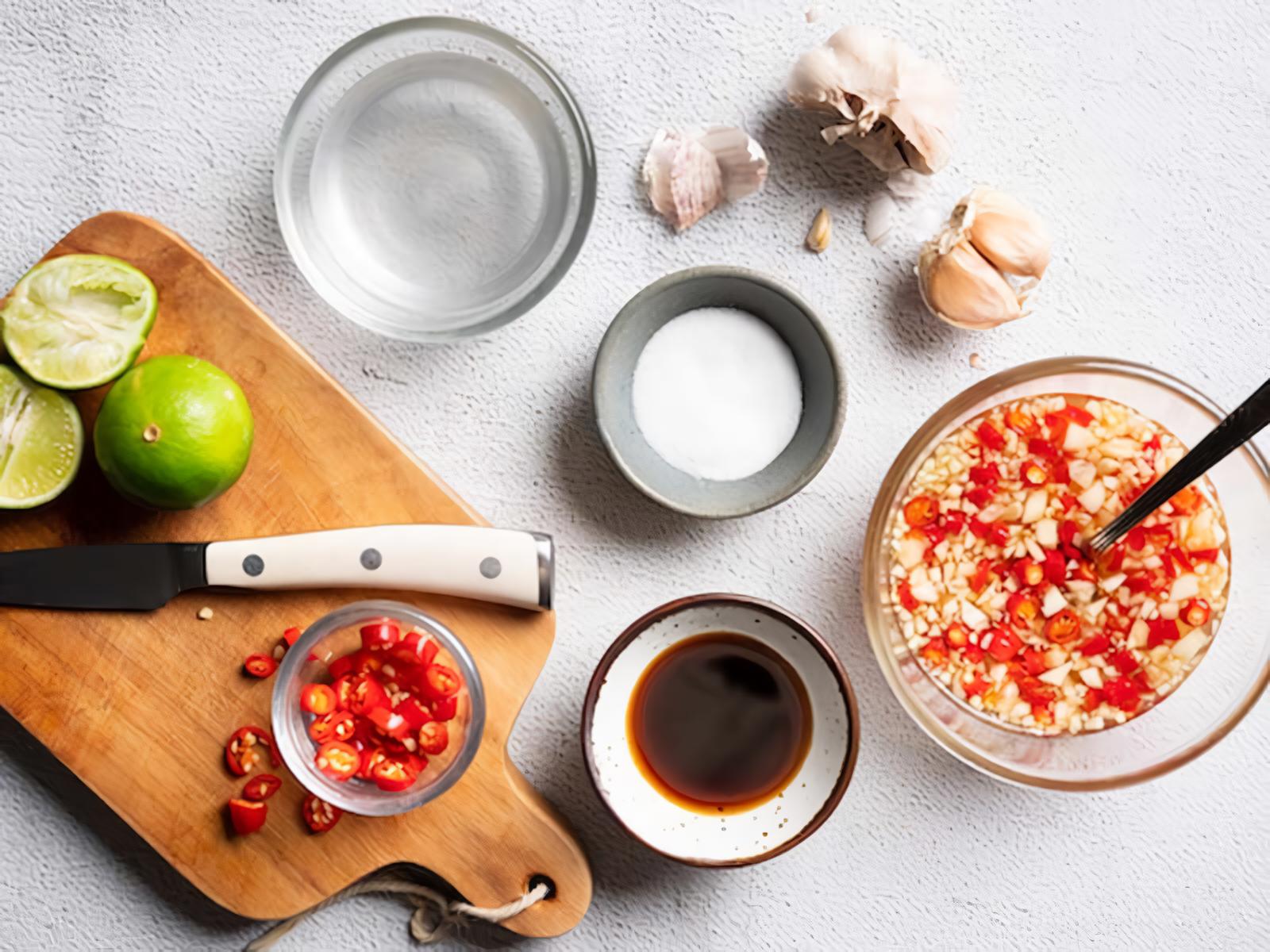 Les ingr&eacute;dients du nước mắm pha : sauce de poisson, citron vert, ail, piment, sucre et eau, r&eacute;unis pour pr&eacute;parer une sauce aigre-douce qui accompagne &agrave; merveille les b&aacute;nh khọt du Sud du Vietnam.