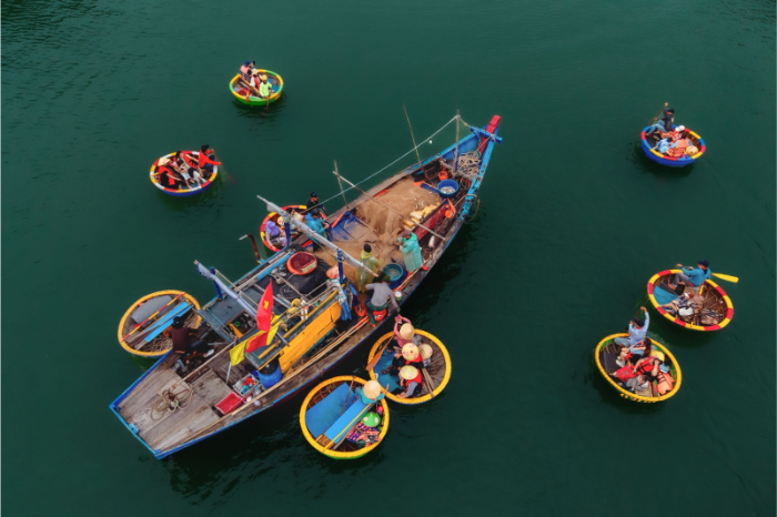 Au large des c&ocirc;tes vietnamiennes, les &eacute;changes s'effectuent encore entre bateaux de p&ecirc;che et embarcations traditionnelles.