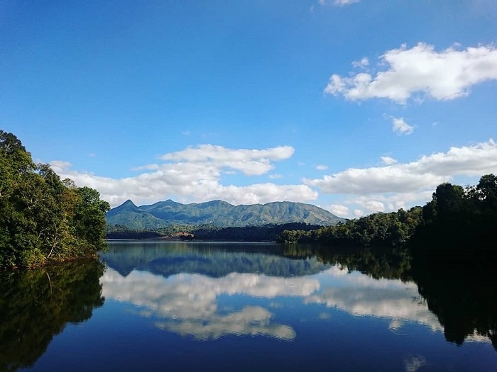 Entouré de collines tapissées de végétation luxuriante et de forêts profondes, le lac Pá Khoang s’étend comme un miroir tranquille